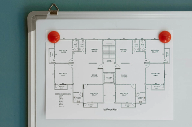 A whiteboard with a house blueprint attached